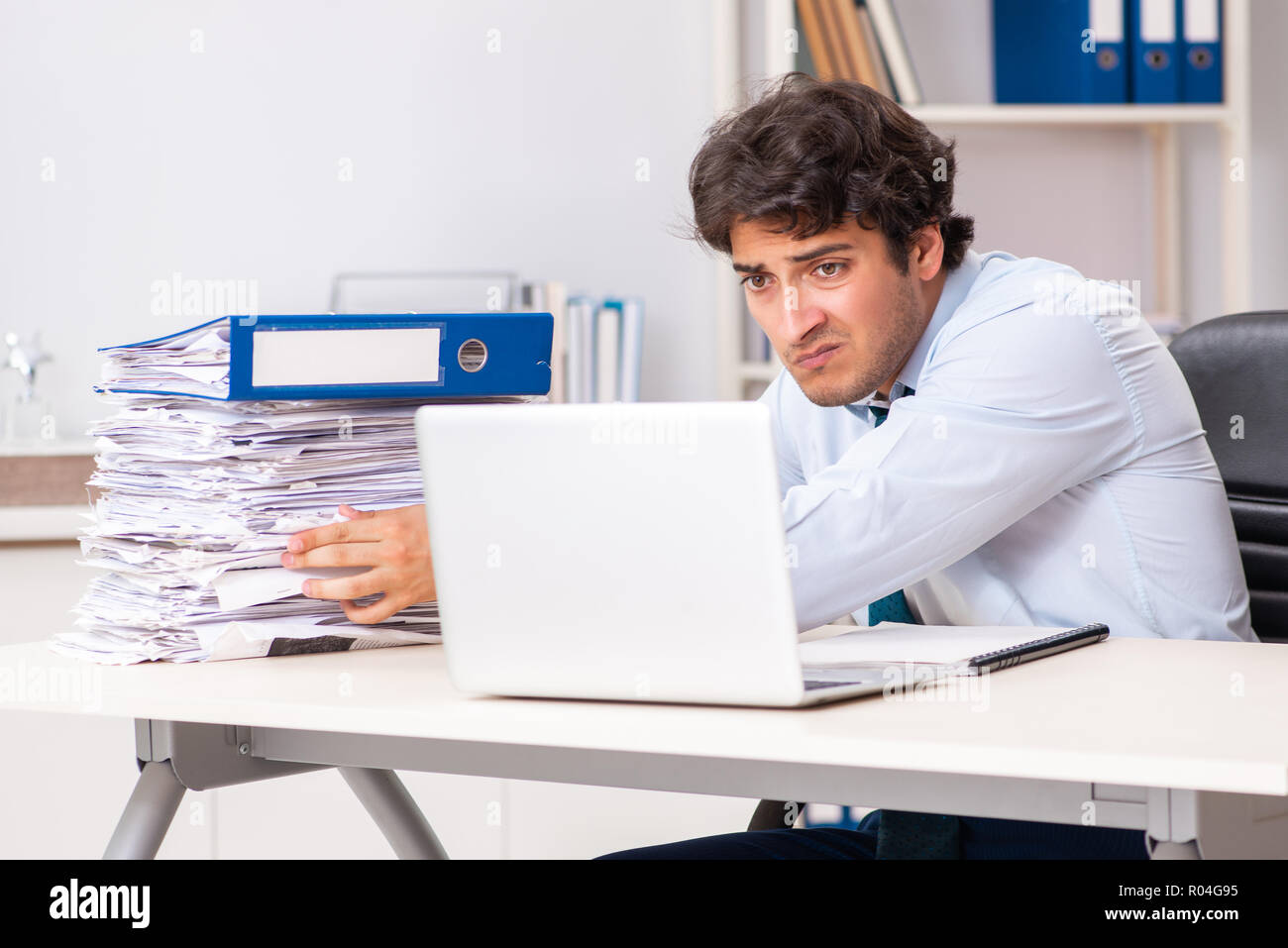 Overloaded busy employee with too much work and paperwork Stock Photo
