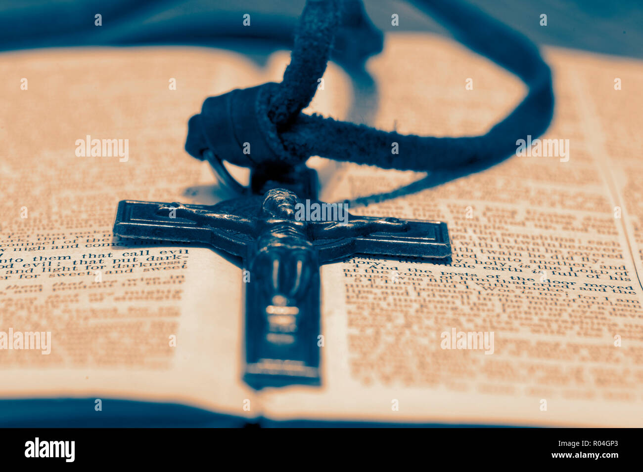 Crucifix necklace on a bible page on wood background with toning Stock Photo