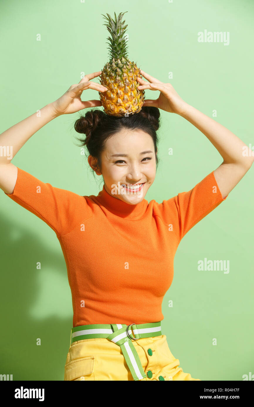 Young woman holding a pineapple Stock Photo
