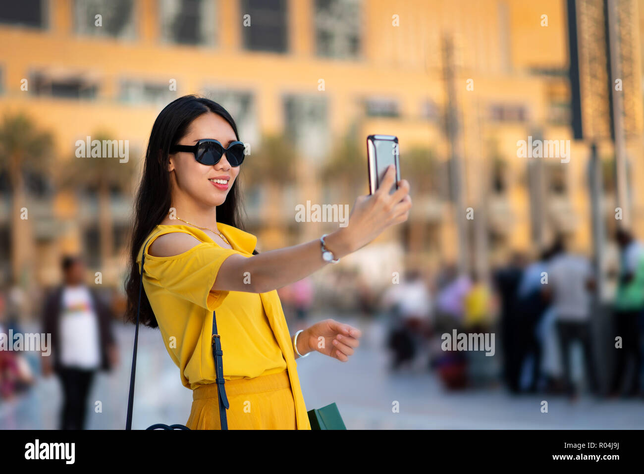 Happy Asian tourist taking selfie at Dubai mall Stock Photo