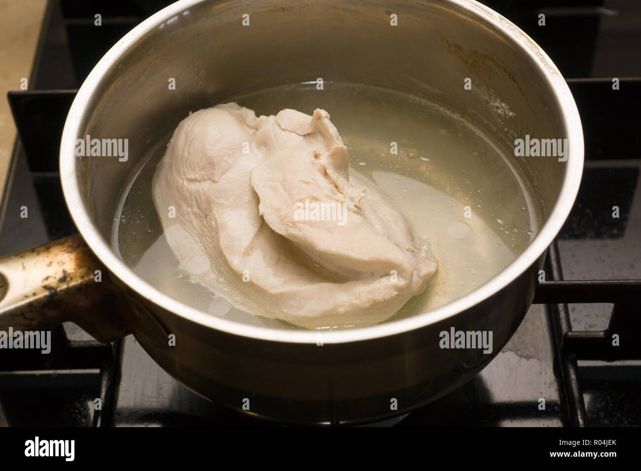 in a saucepan of boiling water a piece of meat is boiled Stock Photo