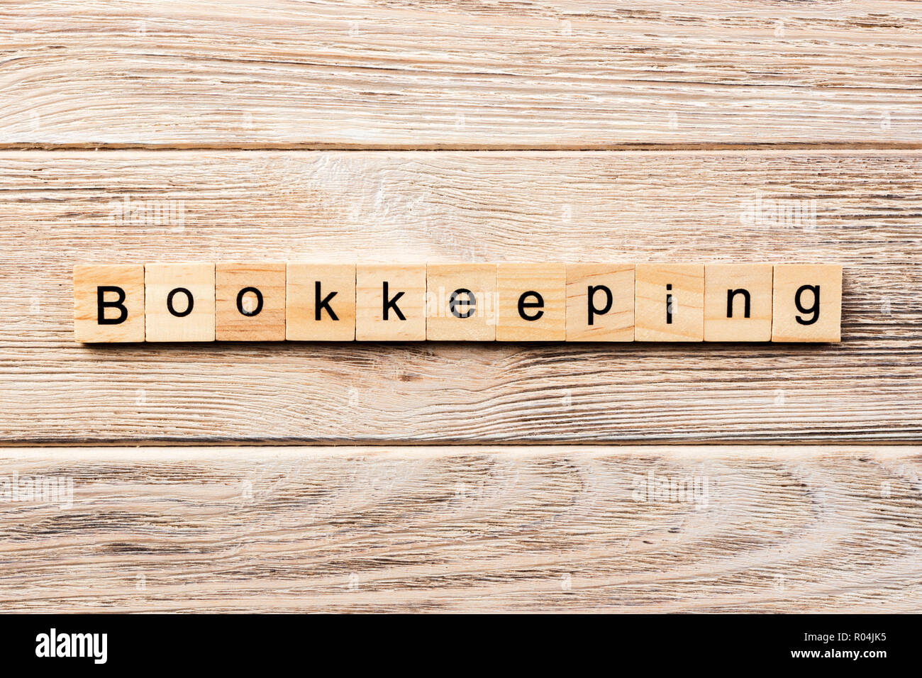 bookkeeping word written on wood block. bookkeeping text on table, concept. Stock Photo