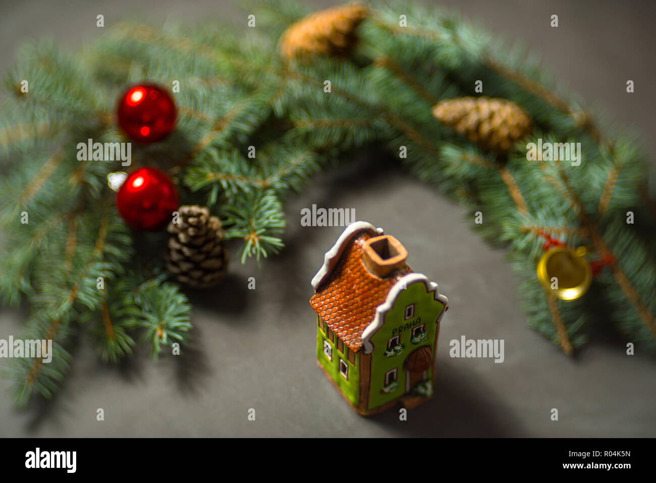 Ceramic green toy house with fir and red globes. Stock Photo