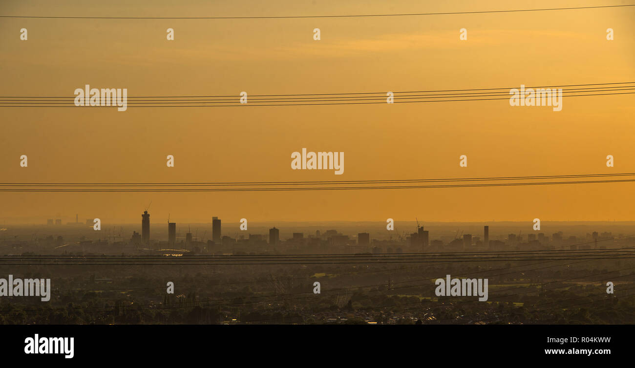 The sky appears yellow as the sun sets over Greater Manchester on a misty evening Stock Photo