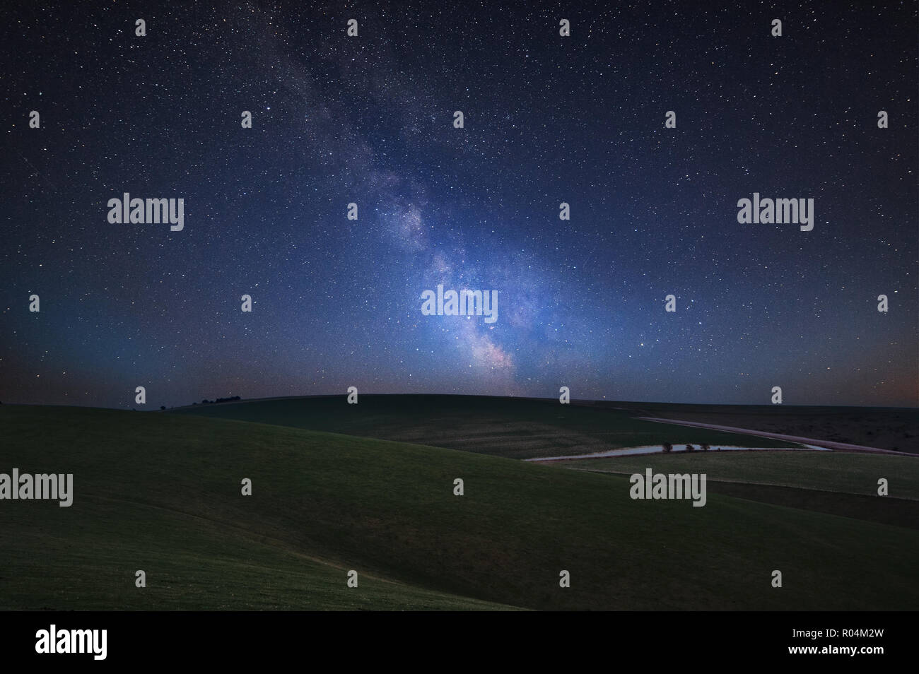 Stunning vibrant Milky Way composite image over landscape of rolling ...