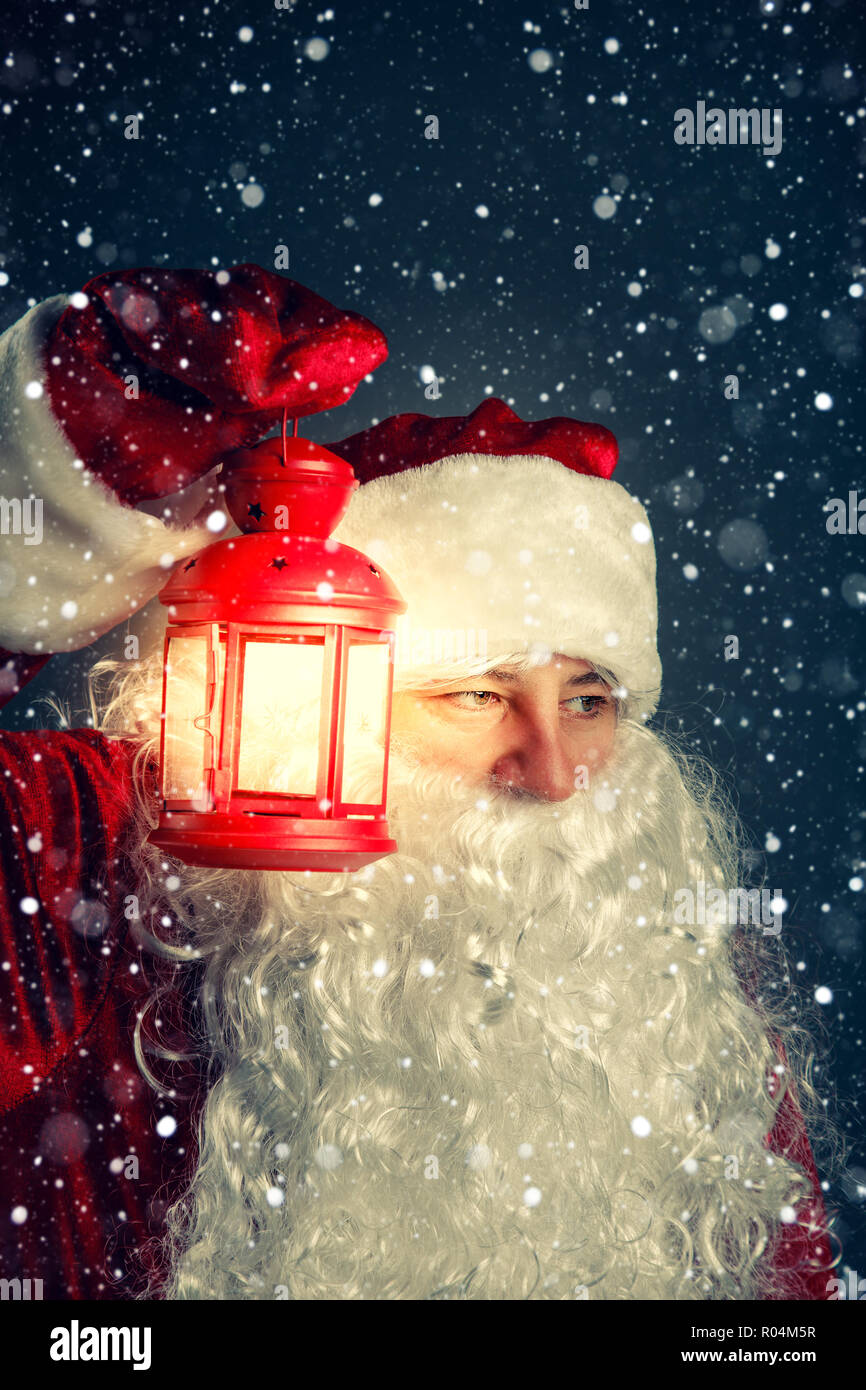 Authentic Santa Claus with a lantern. Christmas night. Stock Photo