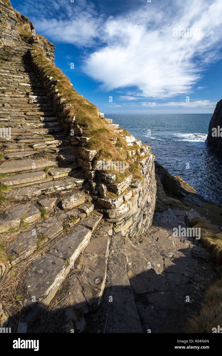 Whaligoe steps - steep stony stairs leads all the way down to the small beach below high cliffs near Whaligoe village, Highlands of Scotland. Stock Photo