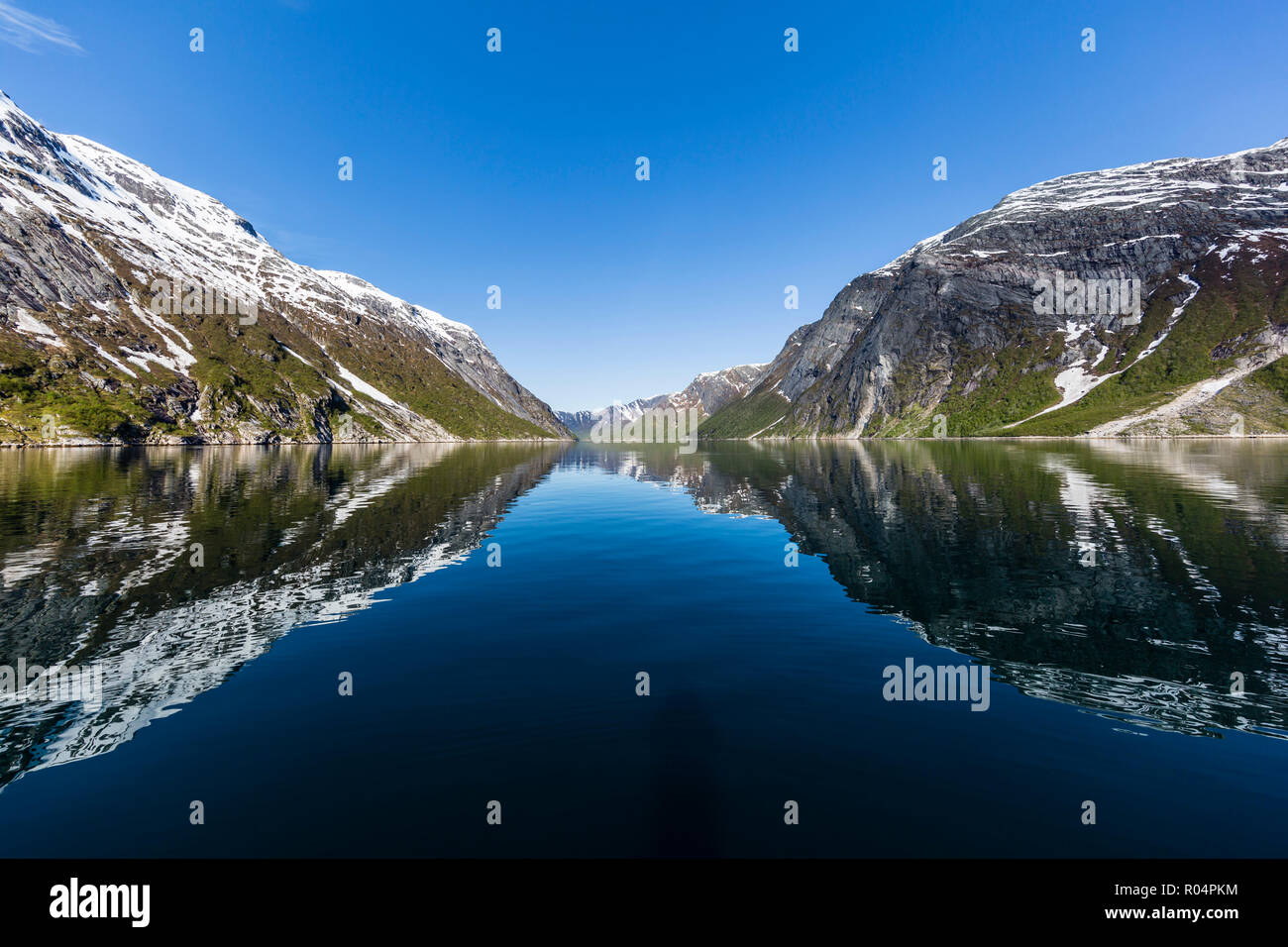 Snow-capped mountains reflected in the calm waters of Nordfjord, deep inside of Melfjord, Norway, Scandinavia, Europe Stock Photo