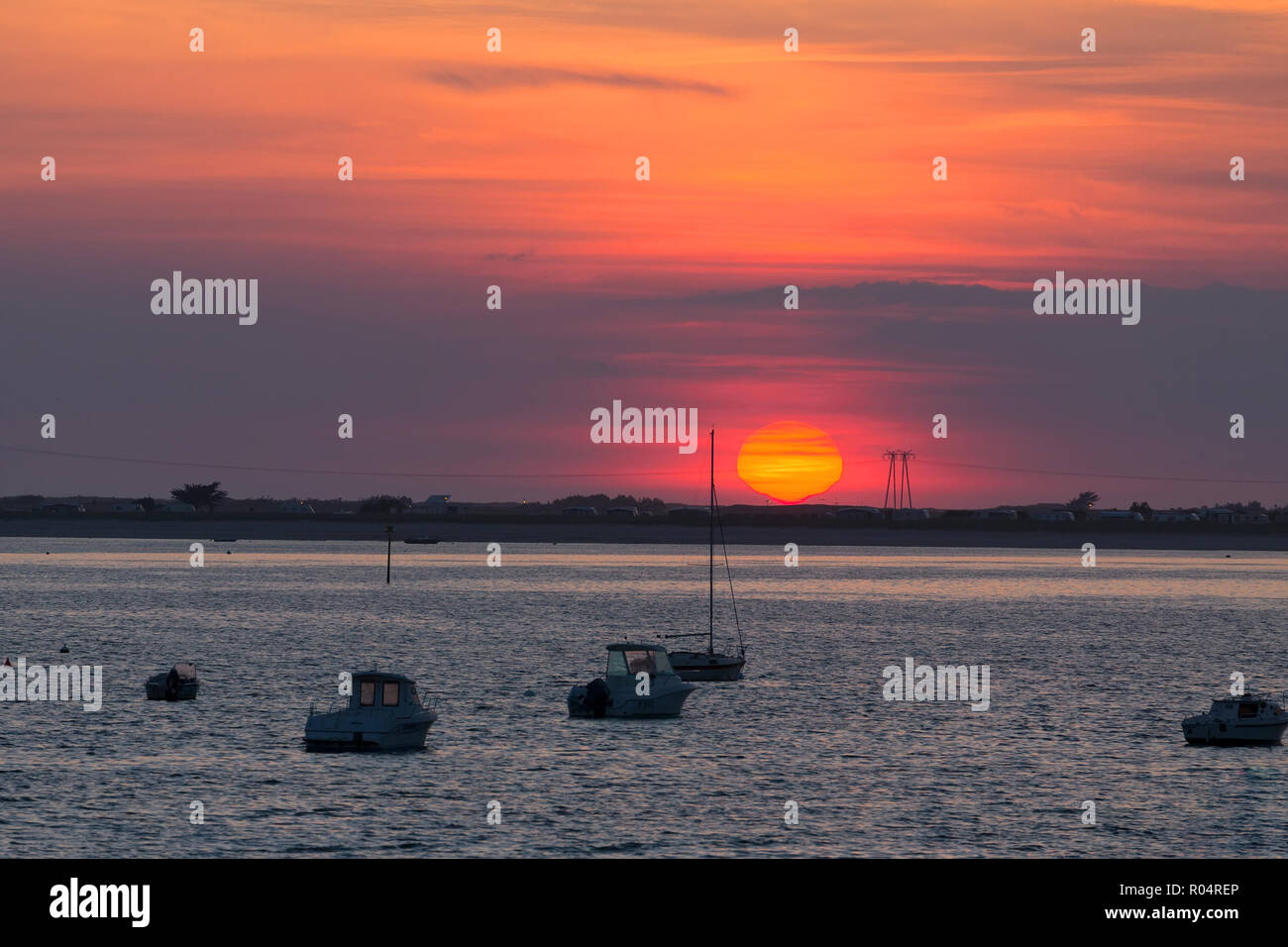 Red sunset over Carnac beach with electric pylons, Brittany, France Stock Photo