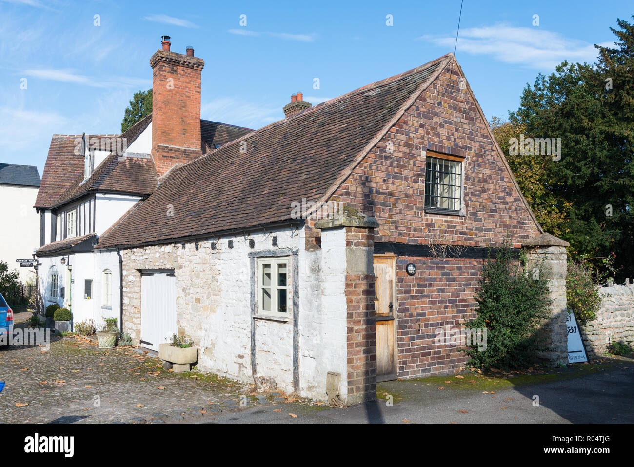 Old half timber-framed house with attached brick garage and storeroom in Much Wenlock, Shropshire Stock Photo