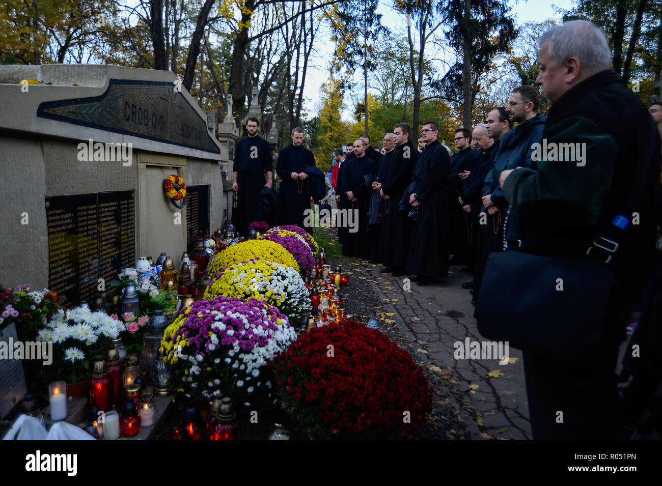 Krakow, Poland. 1st Nov, 2018. Monks are seen standing next to a grave at the Rakowicki Cemetery during the celebrations.All Saints Day, also known as The Day of the Dead, is a Roman Catholic day of remembrance of friends and loved ones who have passed away. Credit: Omar Marques/SOPA Images/ZUMA Wire/Alamy Live News Stock Photo