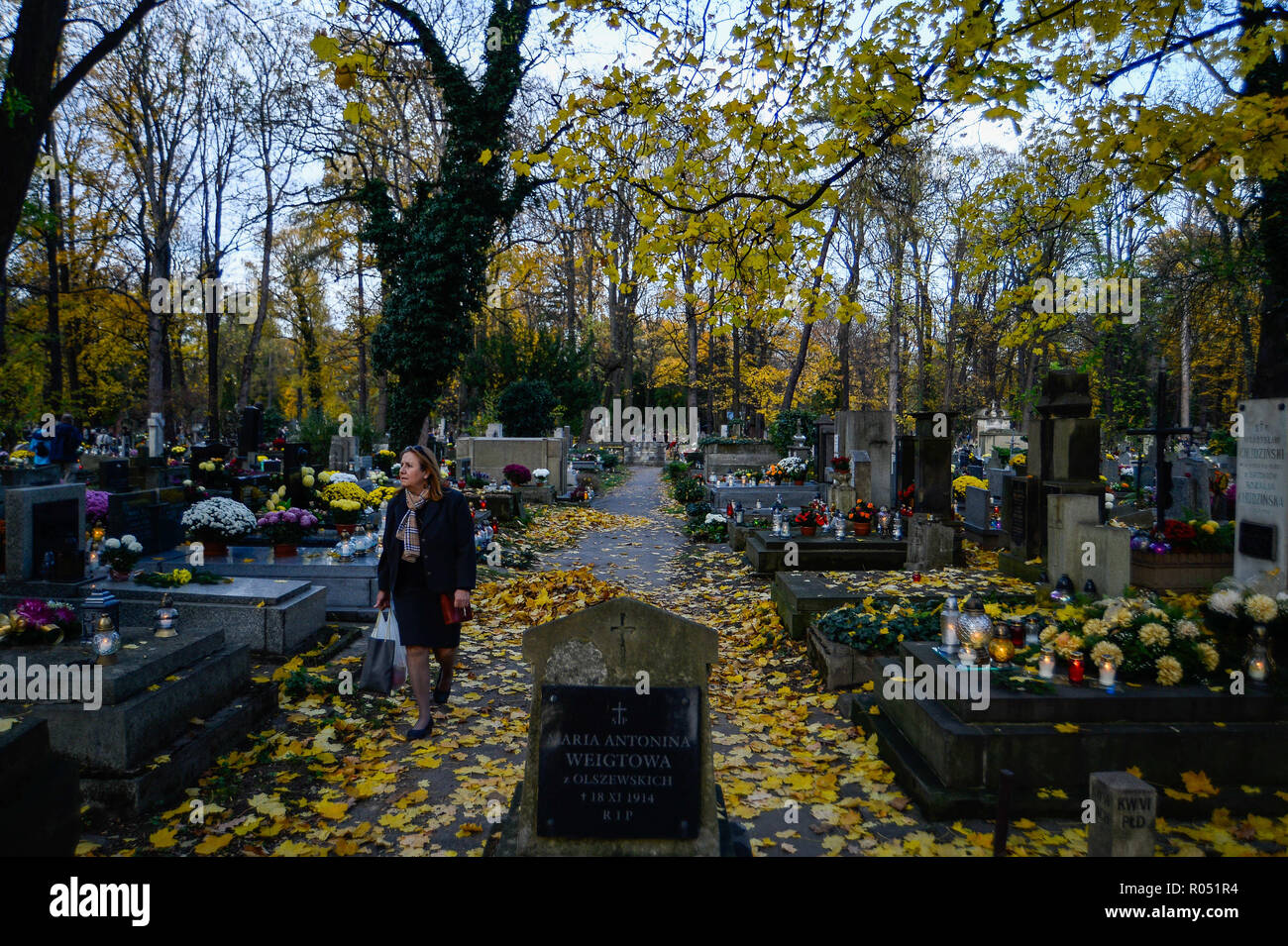 Krakow, Poland. 1st Nov, 2018. A woman seen looking for her relatives graves at the Rakowicki Cemetery during the celebrations.All Saints Day, also known as The Day of the Dead, is a Roman Catholic day of remembrance of friends and loved ones who have passed away. Credit: Omar Marques/SOPA Images/ZUMA Wire/Alamy Live News Stock Photo
