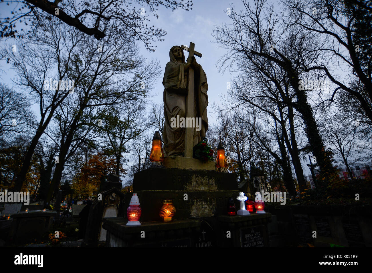 Krakow, Poland. 1st Nov, 2018. A statue seen being surrounded by candles at the Rakowicki Cemetery during the celebrations.All Saints Day, also known as The Day of the Dead, is a Roman Catholic day of remembrance of friends and loved ones who have passed away. Credit: Omar Marques/SOPA Images/ZUMA Wire/Alamy Live News Stock Photo