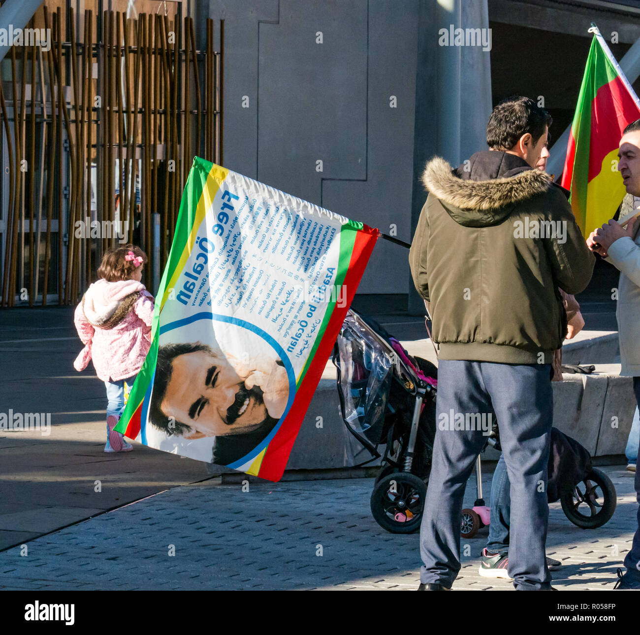 Holyrood, Edinburgh, Scotland, United Kingdom, 2nd November 2018. Kurdish protestors and families stand outside the Scottish Parliament building waving flags supporting the release of Kurdish nationalist Abdullah Öcalan and in protest at the treatment by the Turkish state of Kobane, a city in the Aleppo Governorate in northern Syria Stock Photo