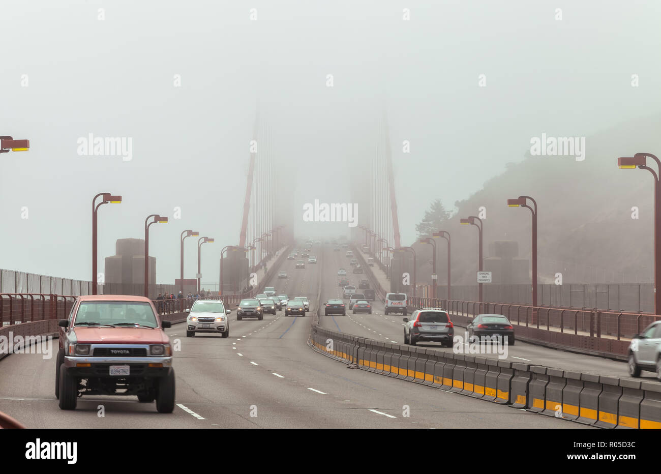Light traffic on the Golden Gate Bridge on a foggy morning, San ...