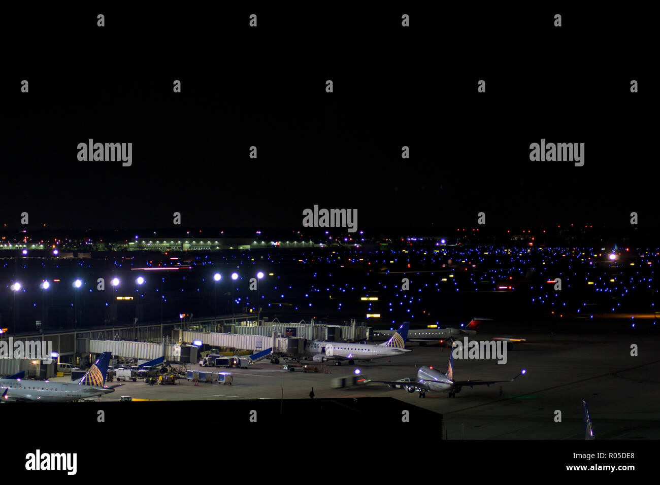 CHICAGO, ILLINOIS, UNITED STATES - MAY 11th, 2018: Several airplanes at the gate at Chicago O'Hare International Airport at night Stock Photo