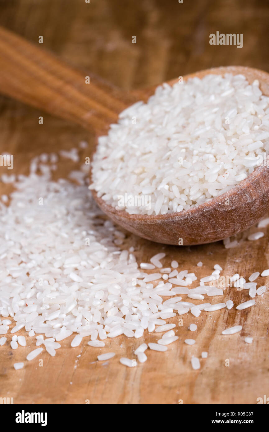 uncooked white rice in a wooden spoon closeup Stock Photohttps. heart_plus....