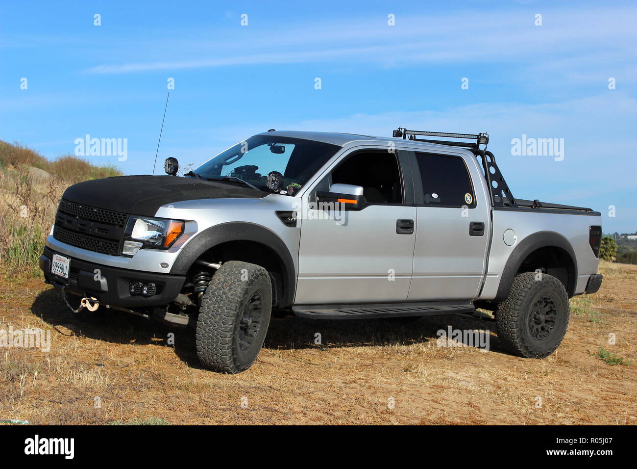 Silver and black customized Ford F150 Raptor SVT on dirt road Stock Photo
