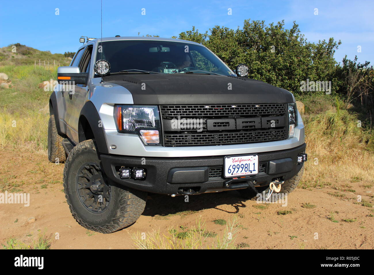 Silver and black customized Ford F150 Raptor SVT on dirt road Stock Photo
