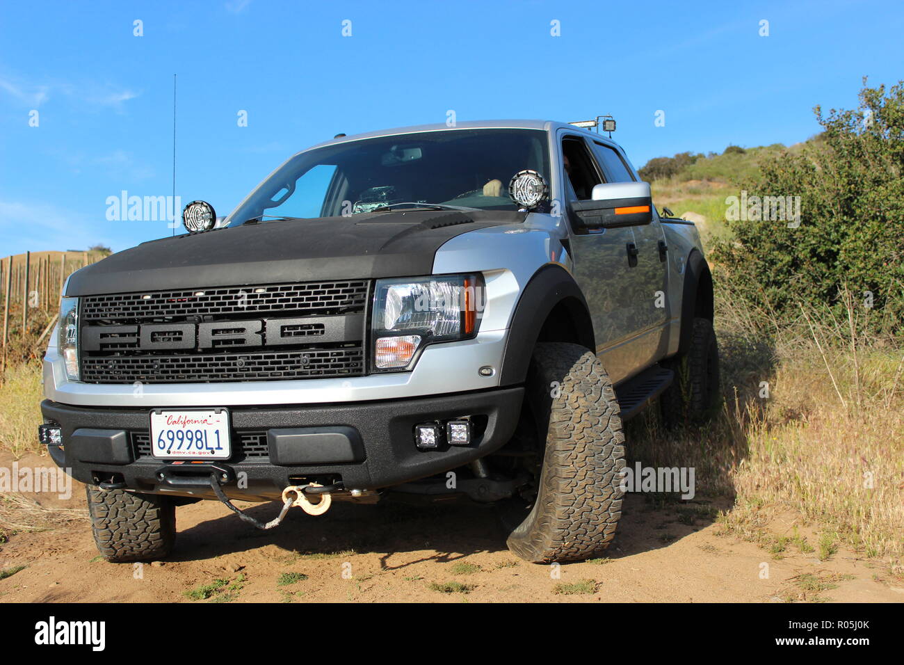 Silver and black customized Ford F150 Raptor SVT on dirt road Stock Photo