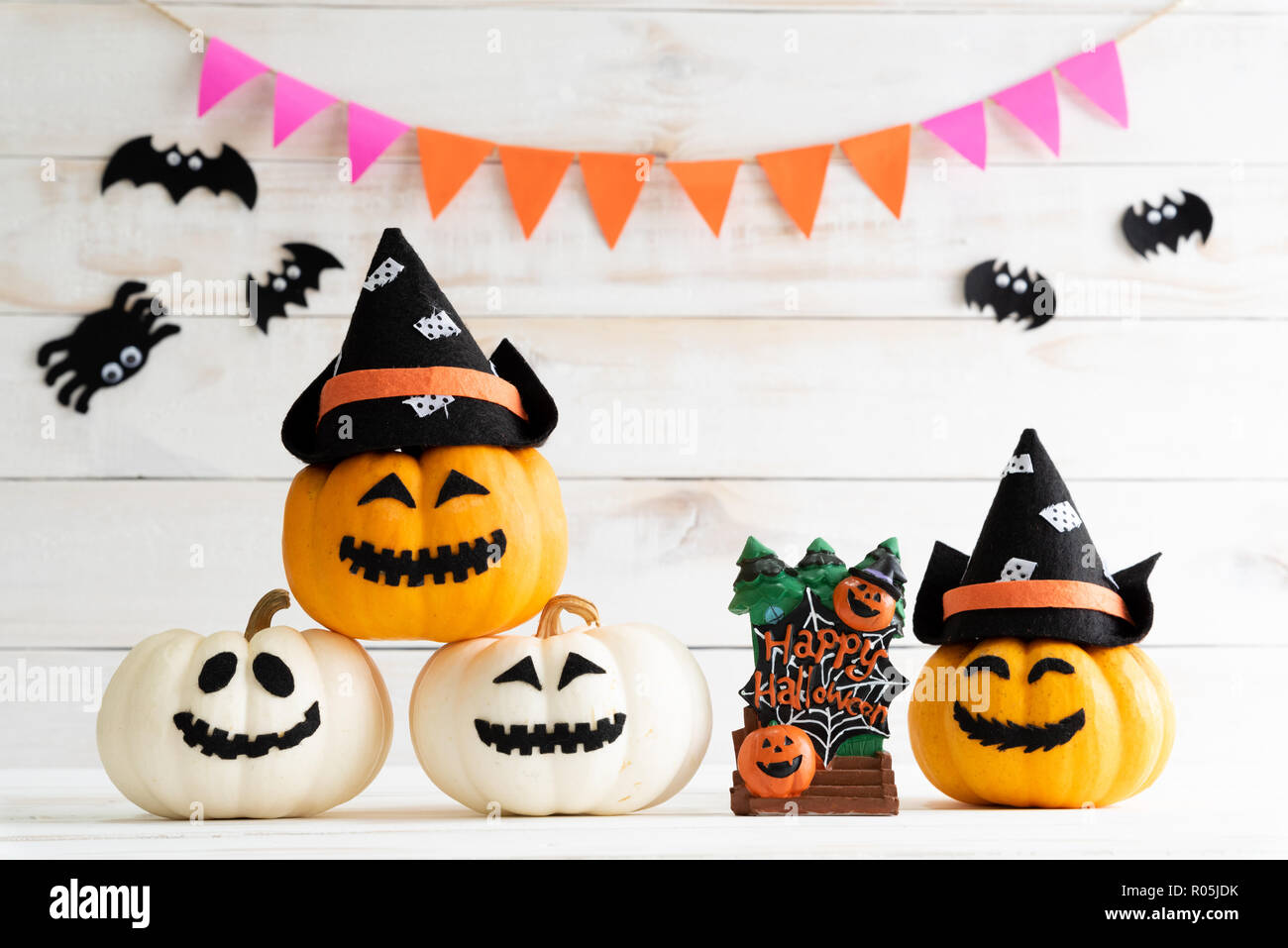White and yellow ghost pumpkins with witch hat on white wooden borad ...