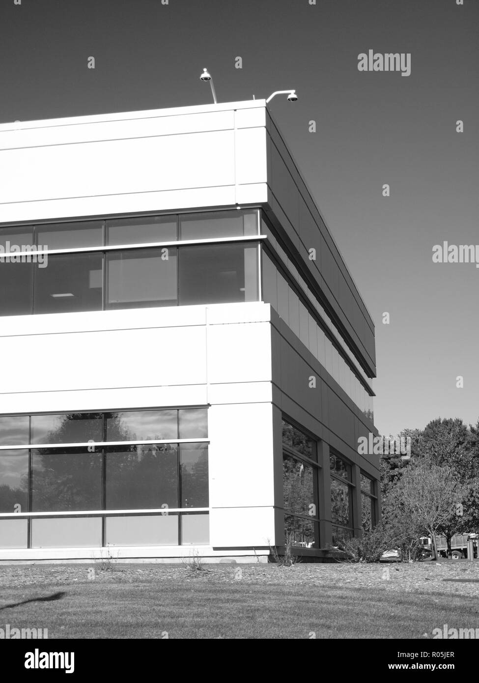 Modern office building in Bergen County, New Jersey. As is the custom recently, security cameras can be seen overlooking the grounds. Black and white . Stock Photo