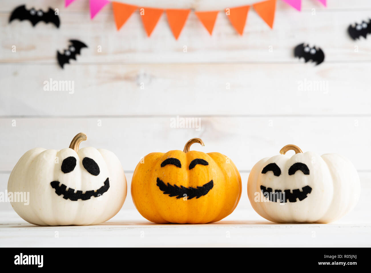 White and yellow ghost pumpkins with witch hat on white wooden borad ...