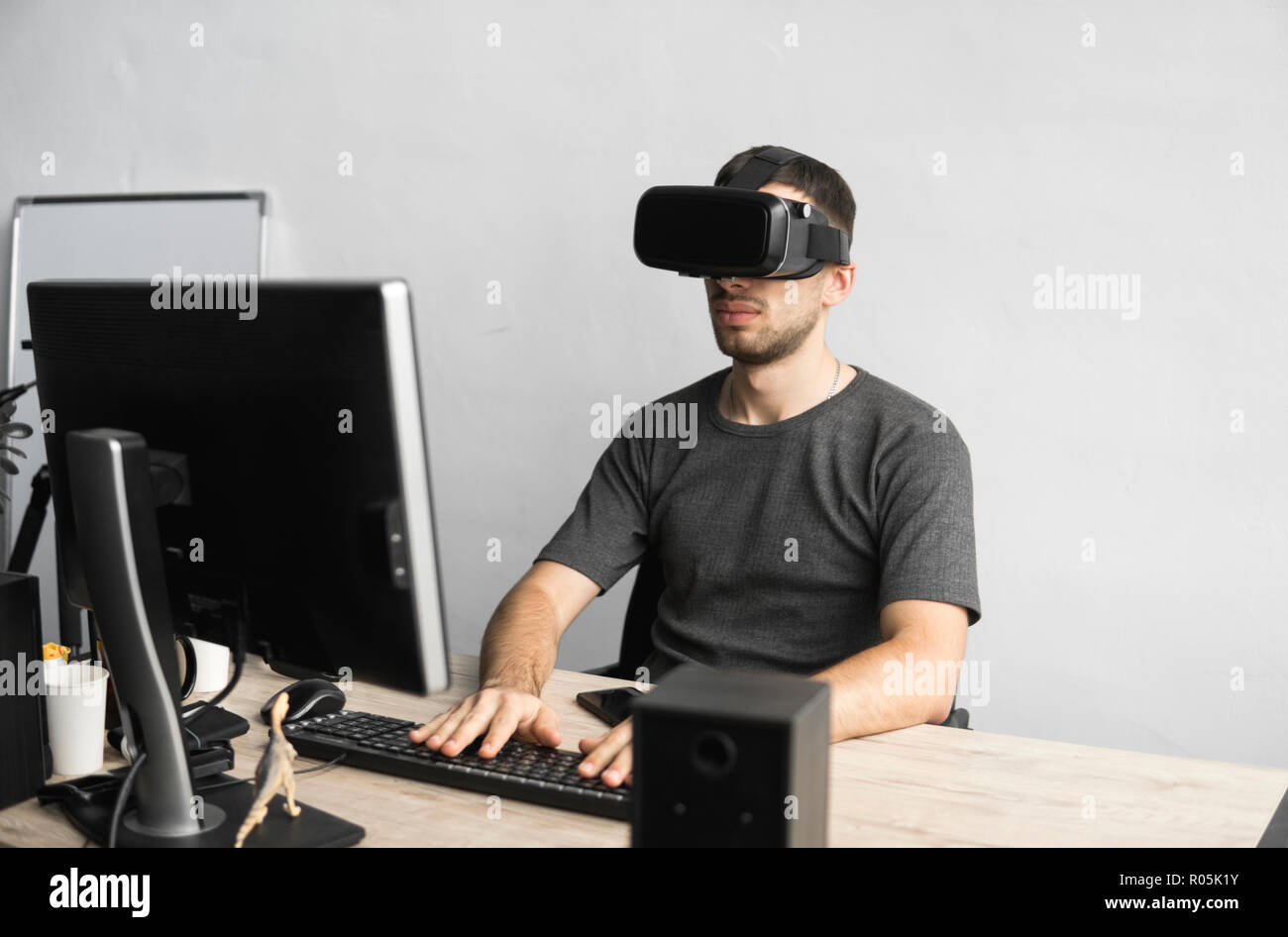Young man wearing virtual reality goggles headset, vr box and sitting