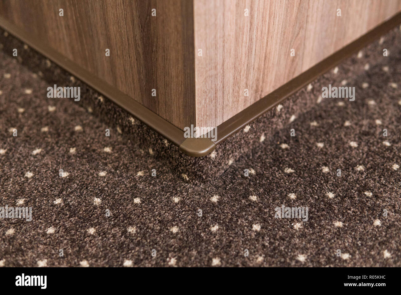 Brown carpet floor with a white dots with a carpet baseboard on a wood