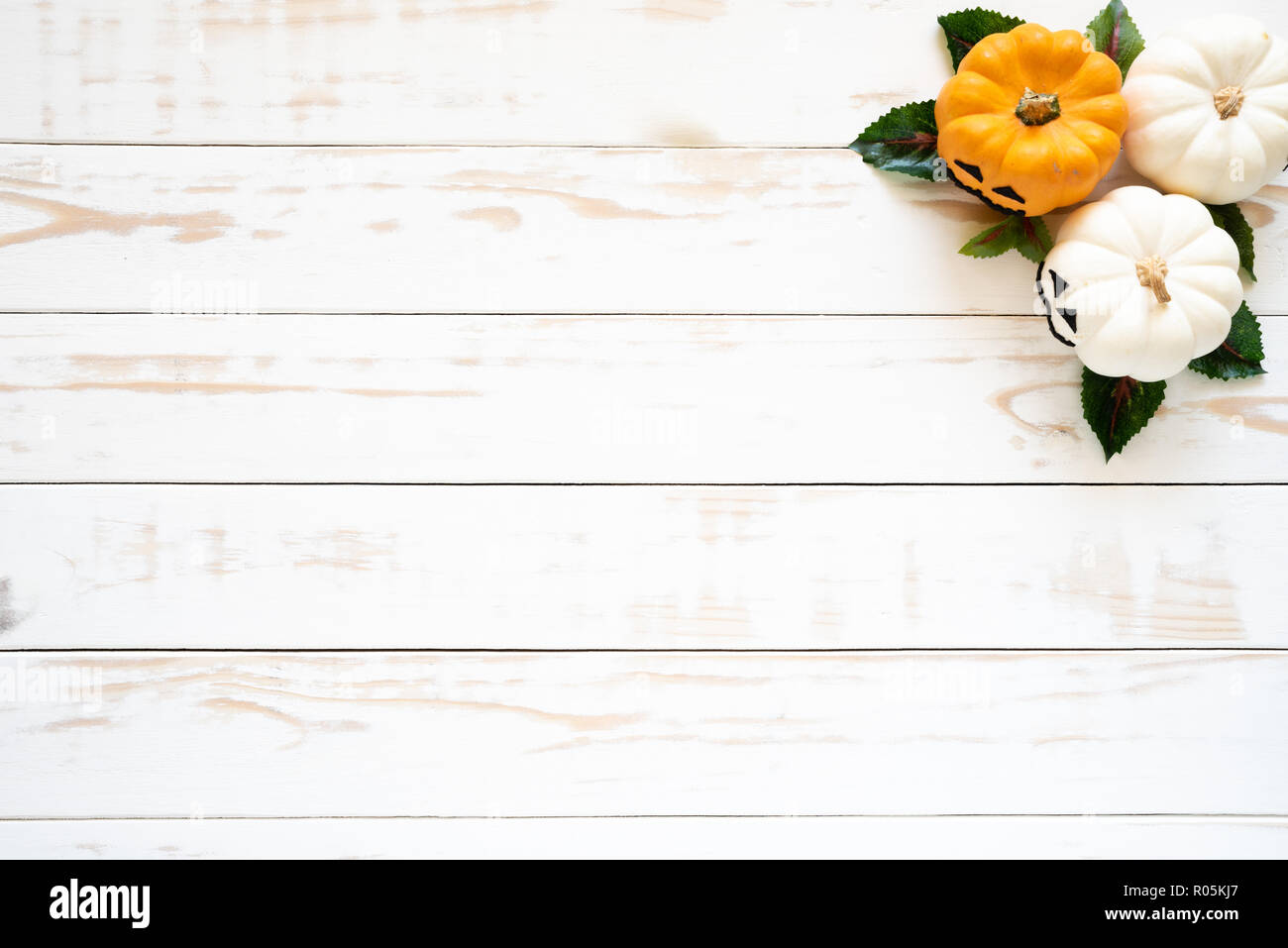 Top view of white and yellow ghost pumpkins on white wooden background ...