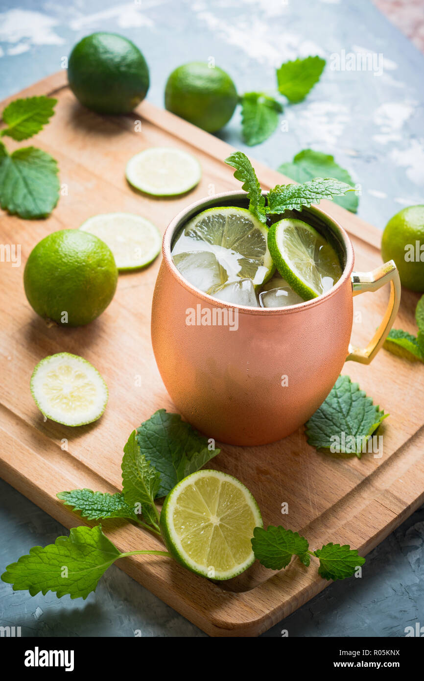 Cold Moscow Mule cocktail in copper mug on the rustic background