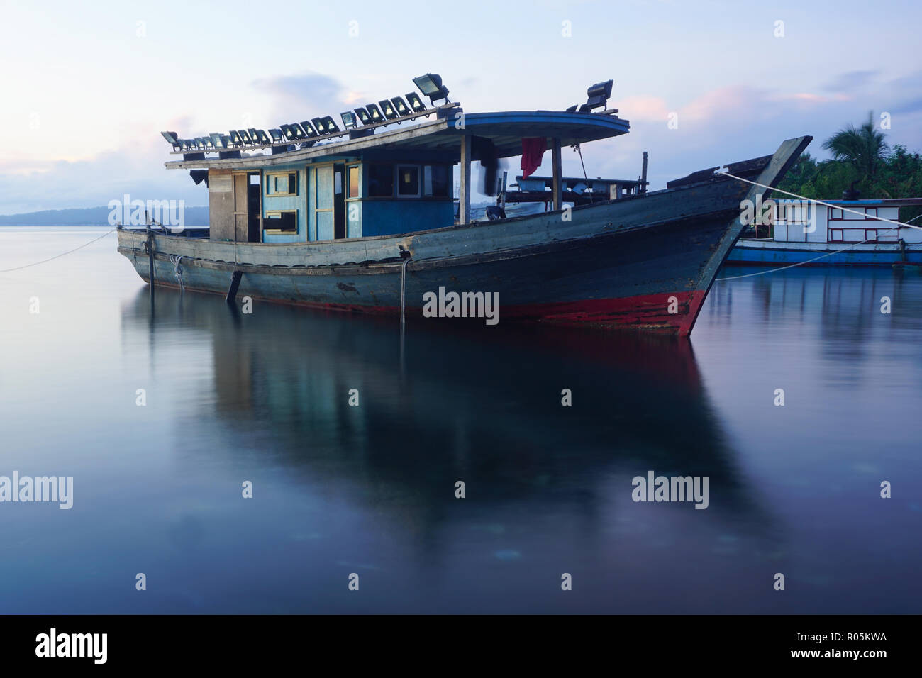 Fishing boat docking near coast, taken with slow shutter camera Stock
