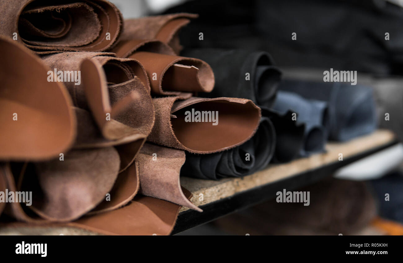 Different pieces of leather in a rolls. The pieces of the colored leathers. Rolls of natural