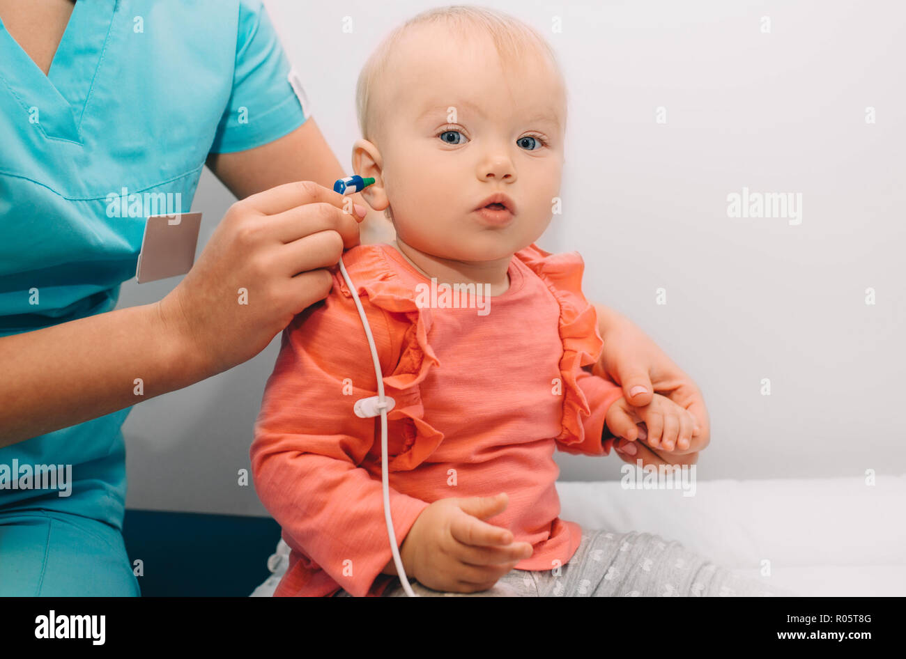 doctor check a baby girl's ears. Hearing exam, baby girl Stock Photo