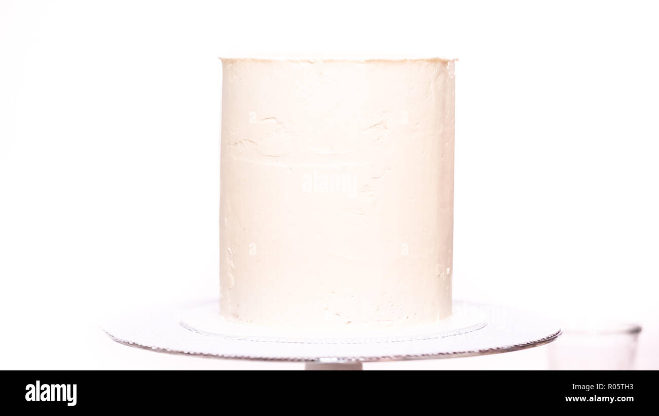 Step by step. Icing tall birthday cake with white buttercream icing