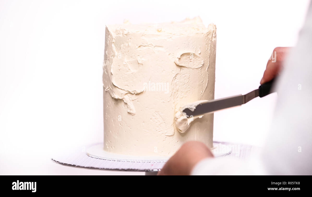 Step by step. Icing tall birthday cake with white buttercream icing