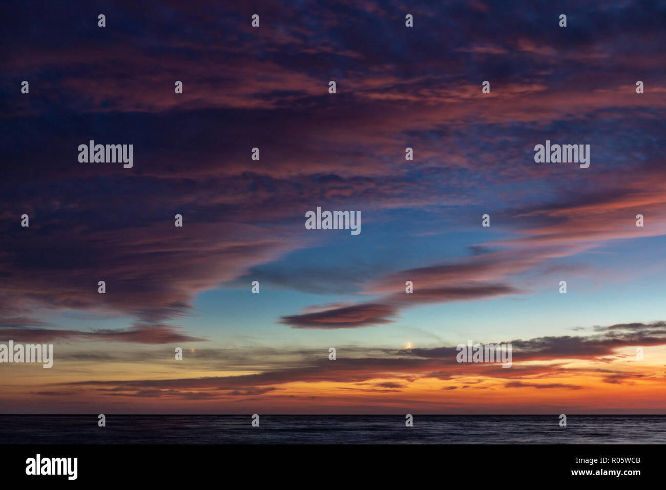 Dramatic colored sky. Moon and star in the clouds. Stock Photo
