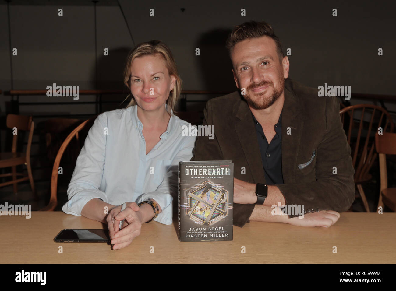 HUNTINGTON, NY-OCT 30: Jason Segel (R) and co-author Kirsten Miller autograph copies of 'OtherEarth - Welcome Back to Reality' at Book Revue. Stock Photo