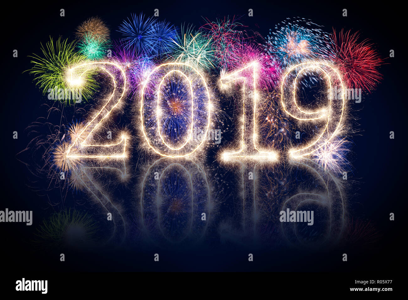 colorful fireworks display and bright sparkler pyrotechnic number 2019 happy new year sylvester concept on black blue background Stock Photo