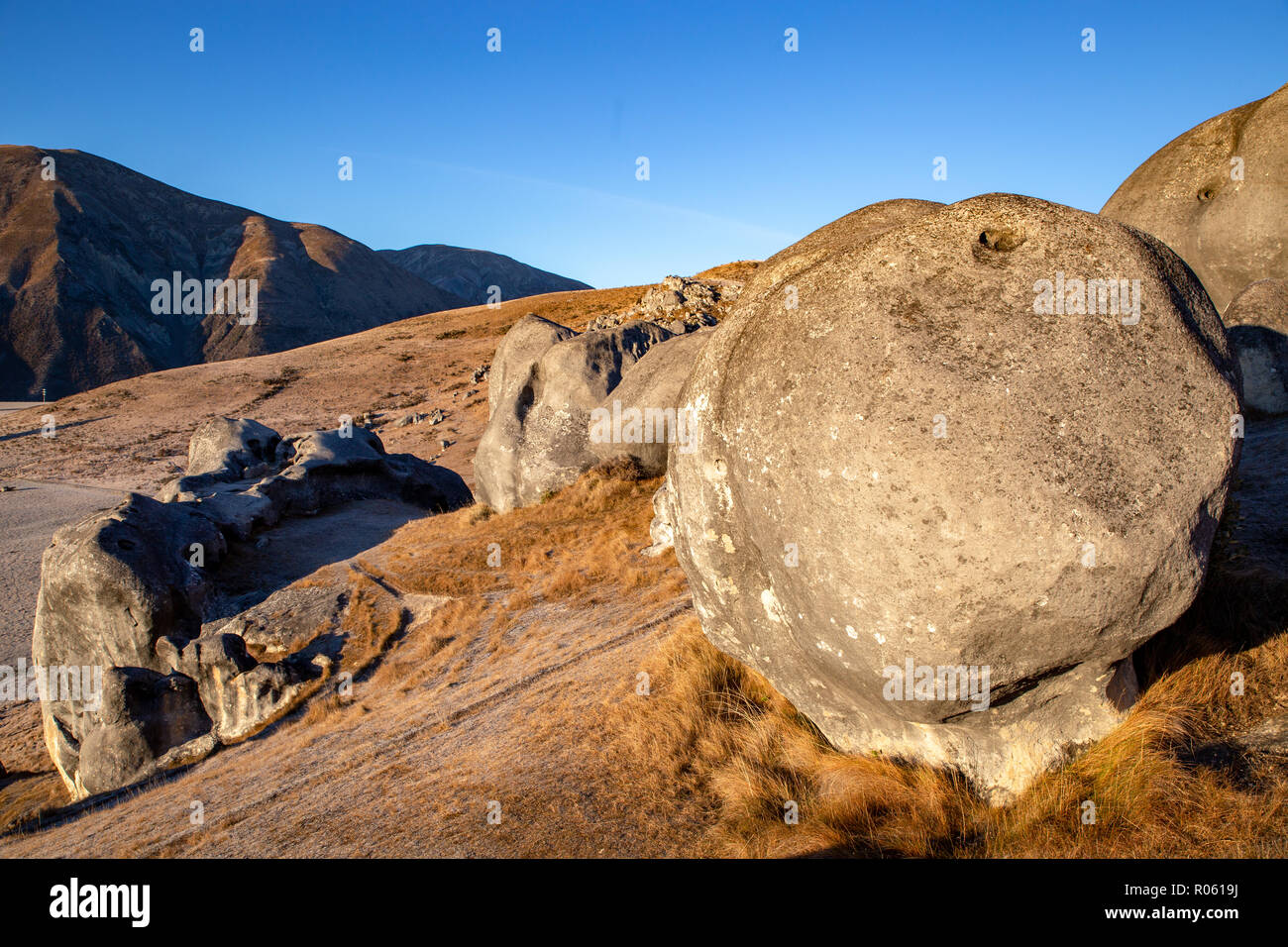A huge boulder sits on the hillside among the castle like rocks in the valley at Castle Hill, New Zealand Stock Photo
