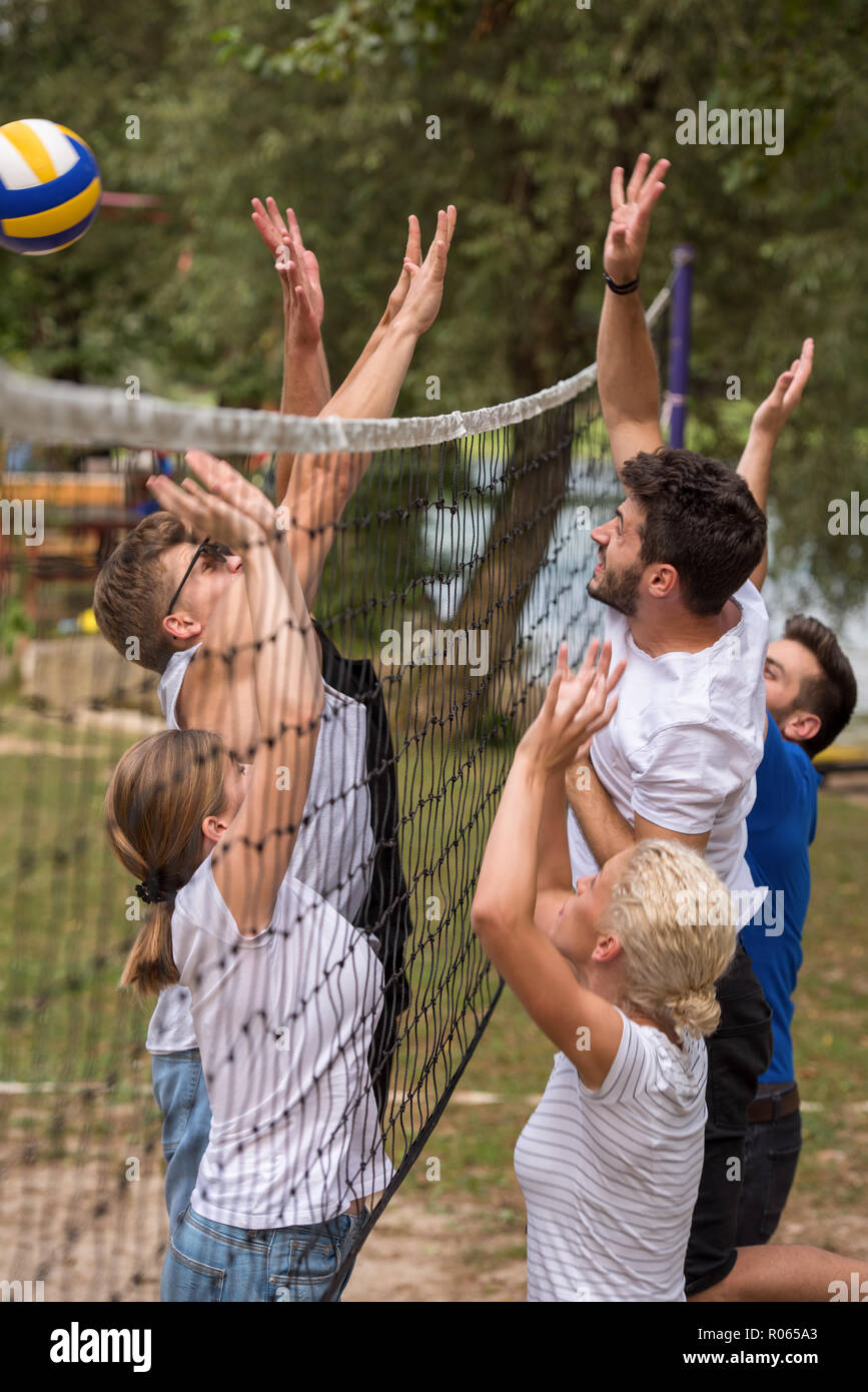 group of young friends playing Beach volleyball in a beautiful nature