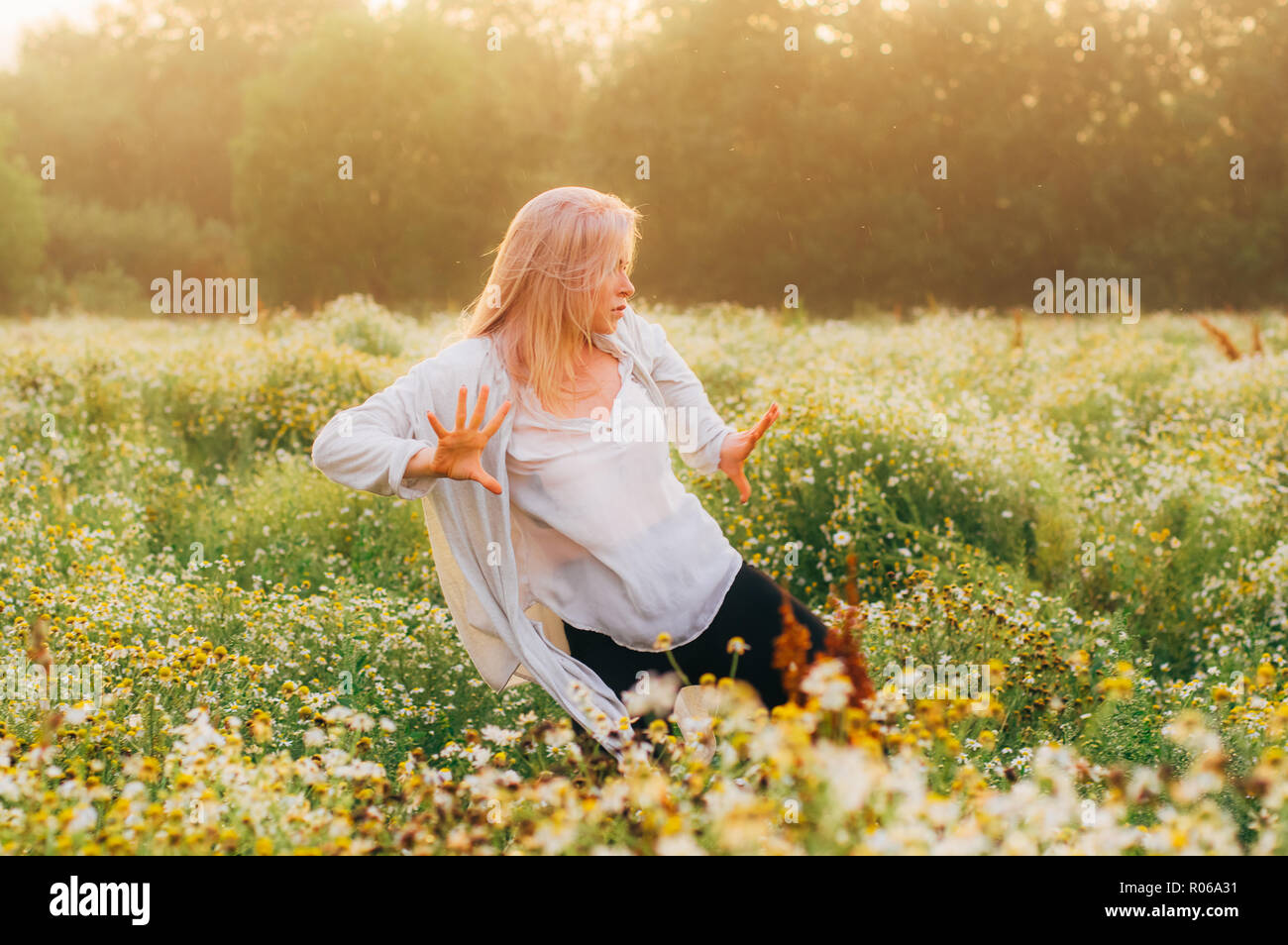 Portrait of young girl dancing in chamomile field in sunrise Stock ...