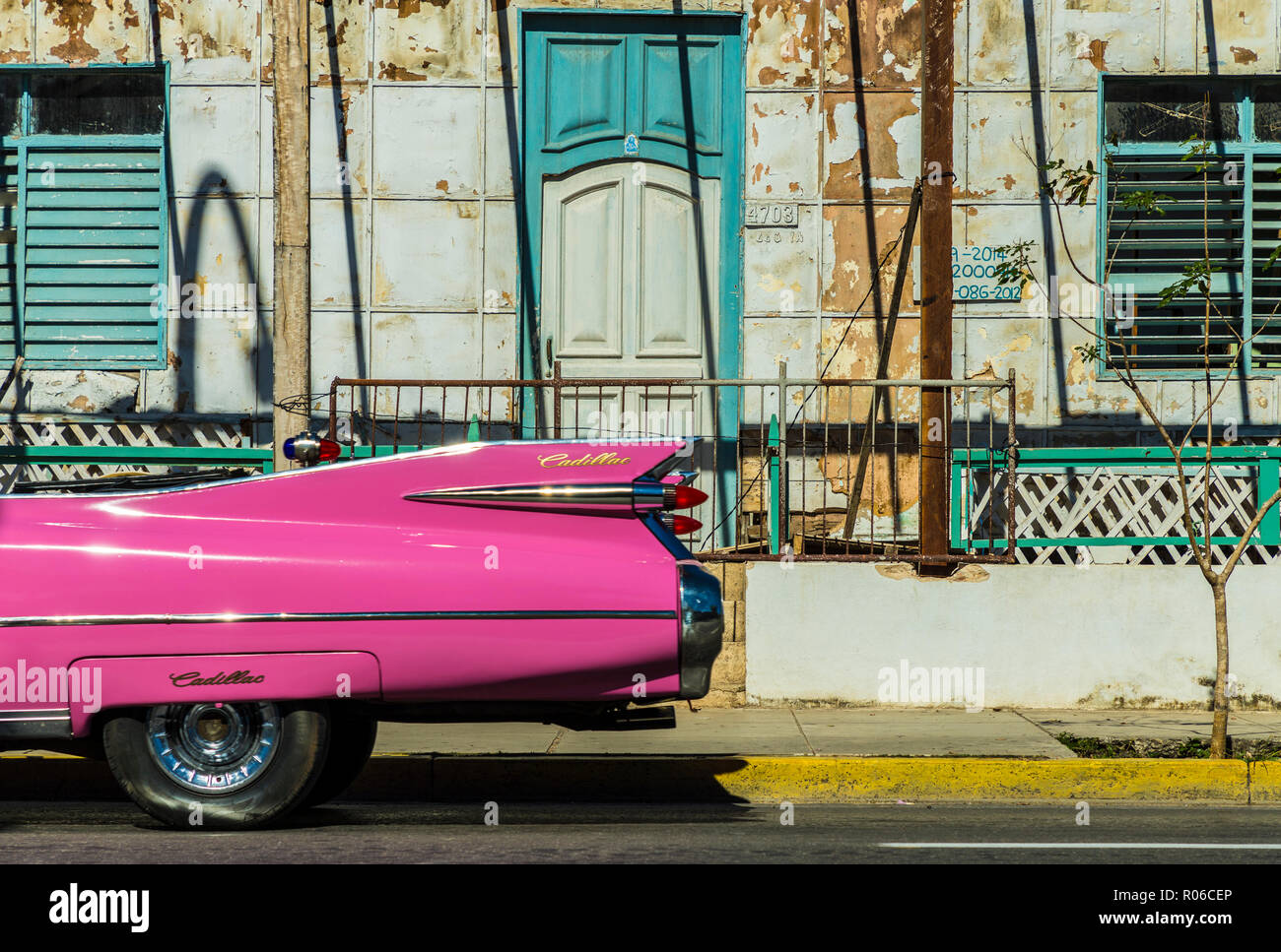 A classic American car driving past an old building in Varadero, Cuba, West Indies, Caribbean, Central America Stock Photo