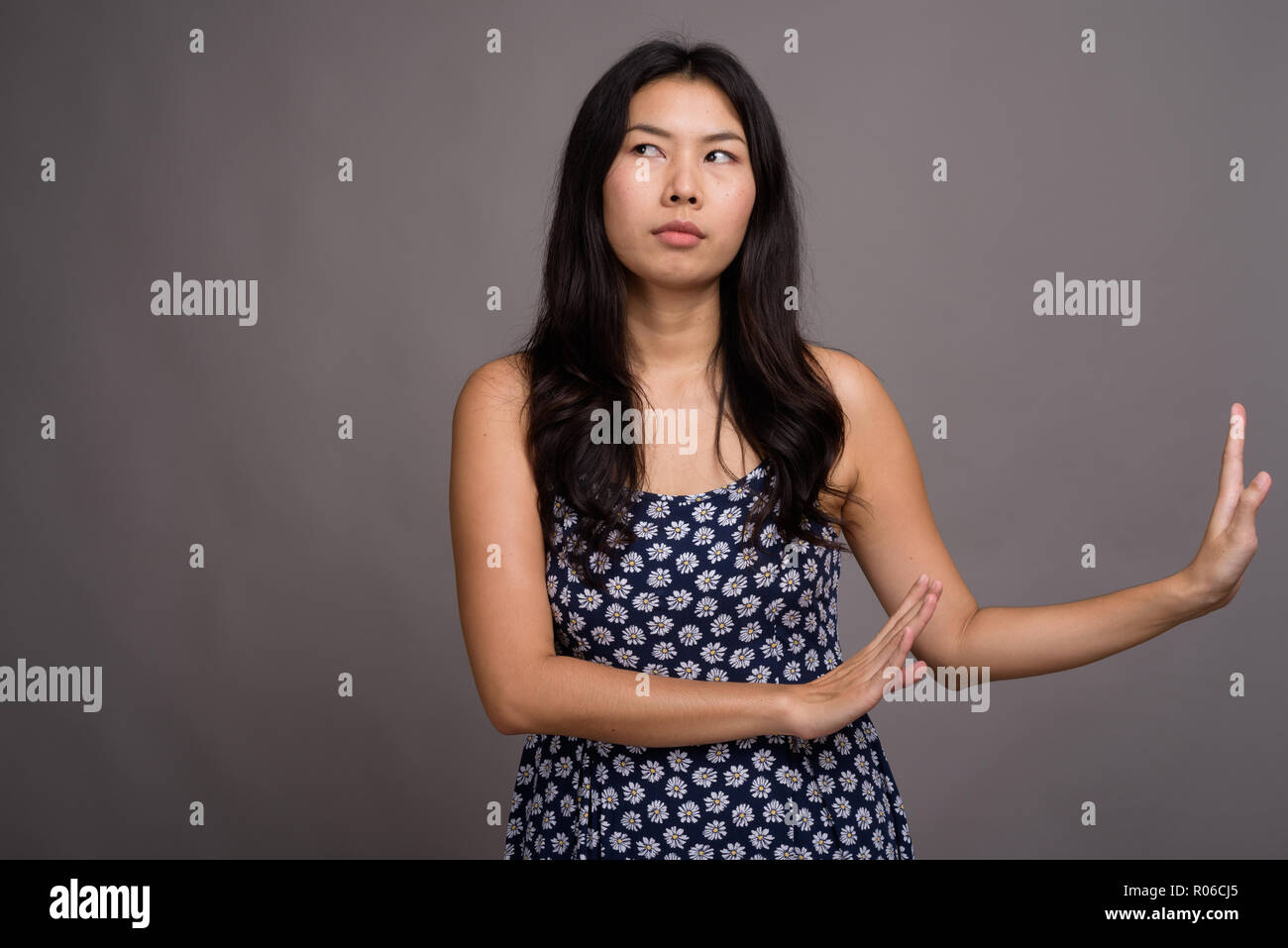 Asian woman wearing blue dress against gray background Stock Photo