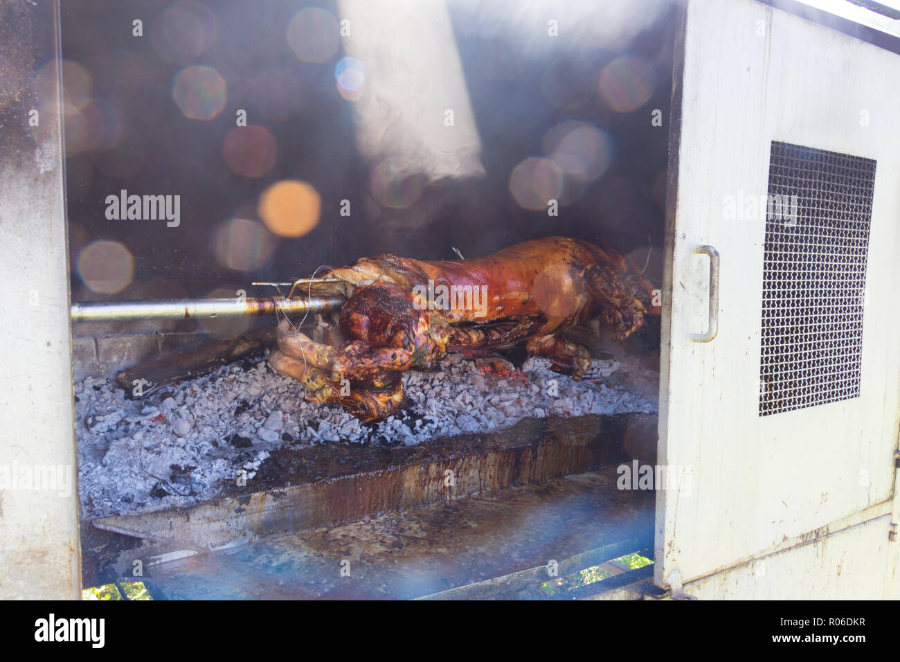 Traditional balkan dish - whole piglet grilled on the open fire. Stock Photo