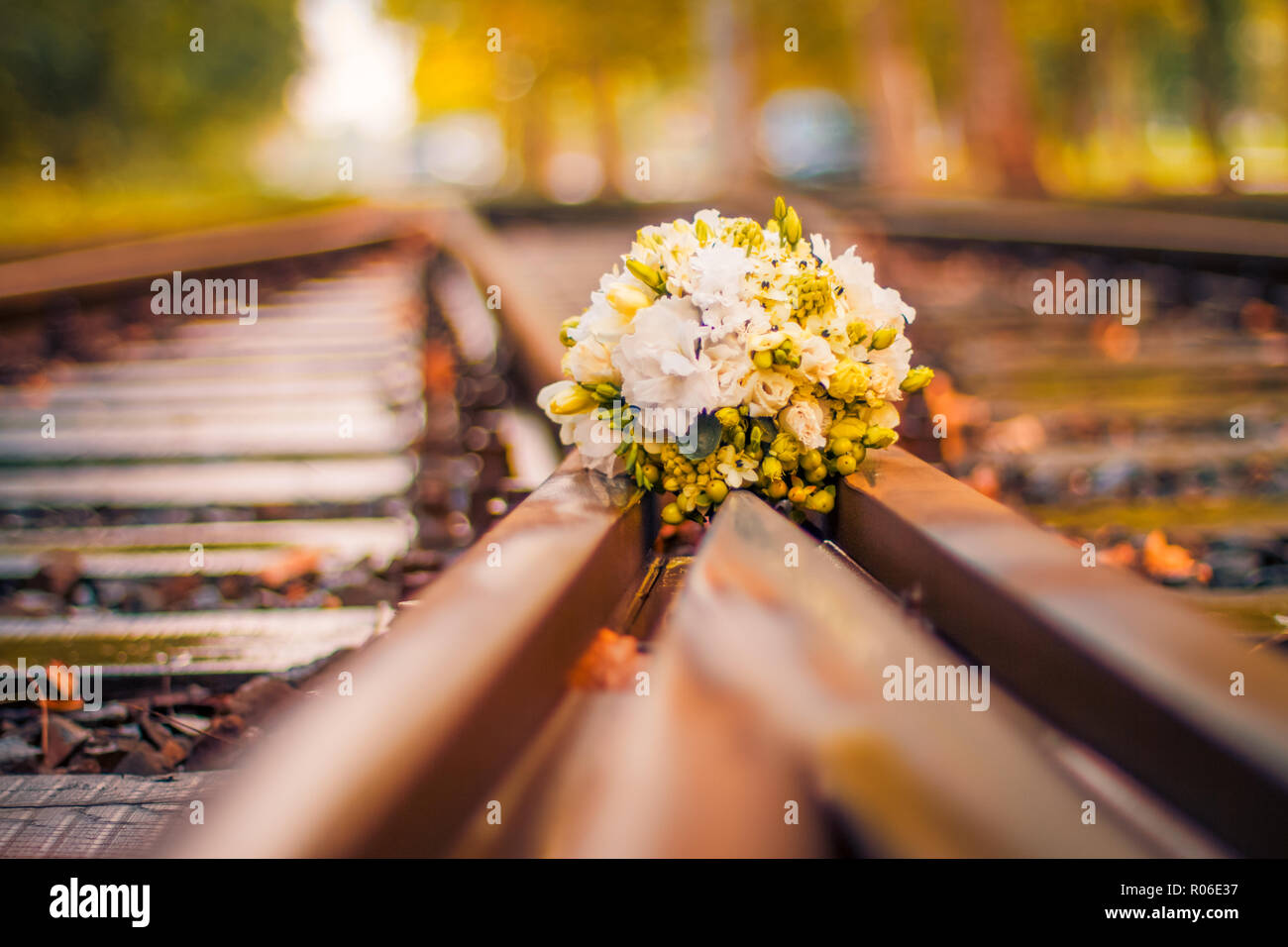 Wedding bouquet lies on railway artistic wedding background, flowers and colorful bokeh background Stock Photo