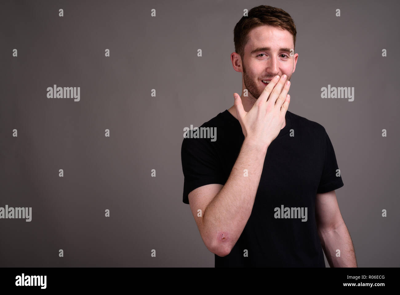 Portrait of young handsome man against gray background Stock Photo