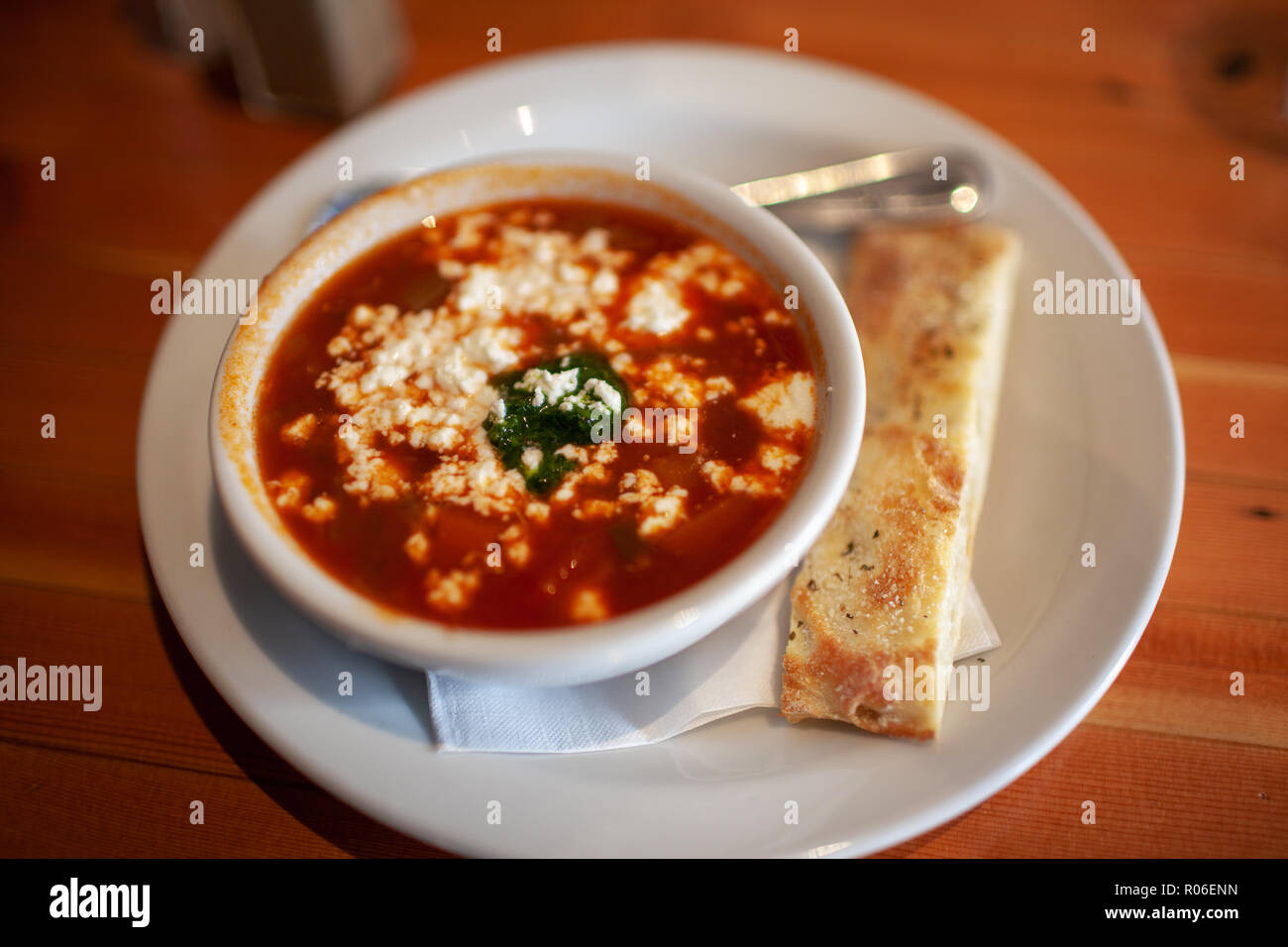 Bowl of Tomato soup with goat cheese and flat bread stick. Stock Photo