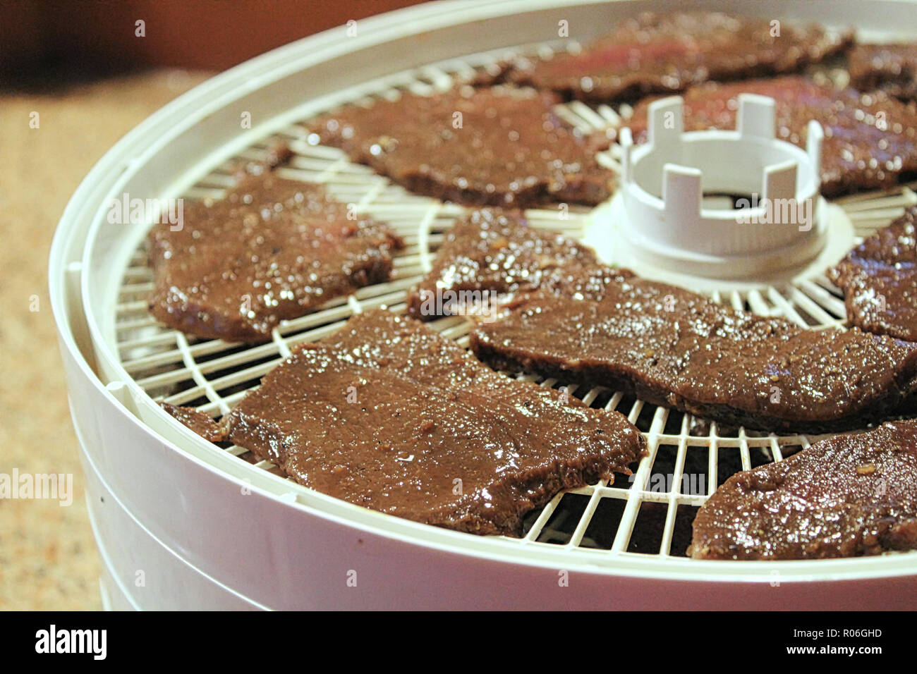 Meat slices laid out on a dehydrator to be made into deer jerky Stock