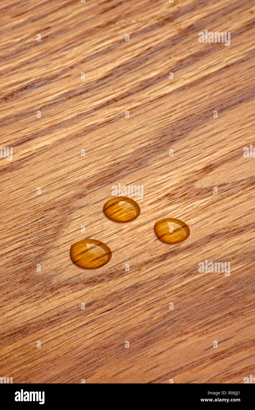 close up of water droplets beaded on a section of varnished shelving wood, Colorado US. Stock Photo